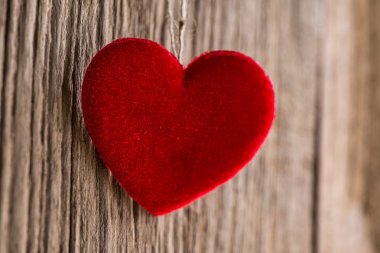 Ahşap doku arka plan üzerinde asılı kırmızı kalp