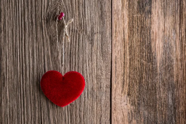 Love heart hanging on wooden texture background — Stock Photo, Image