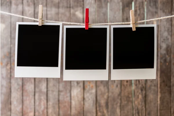 Three blank instant photos hanging on the clothesline — Stock Photo, Image