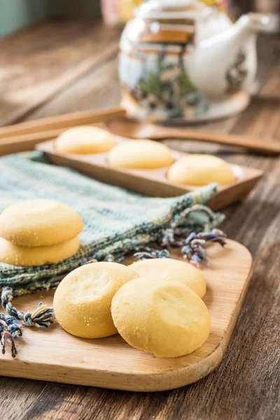 Galletas sobre tela tejida en bandeja de madera — Foto de Stock