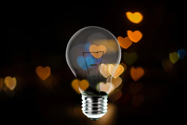 Light bulb with heart shape bokeh background — Stock Photo, Image