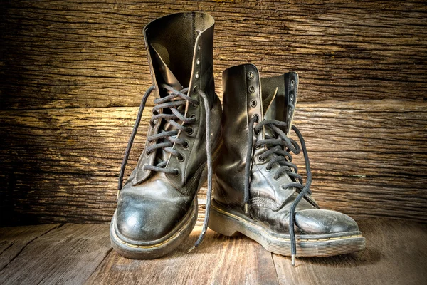 Pair of old boots on wooden floor boards — Stock Photo, Image