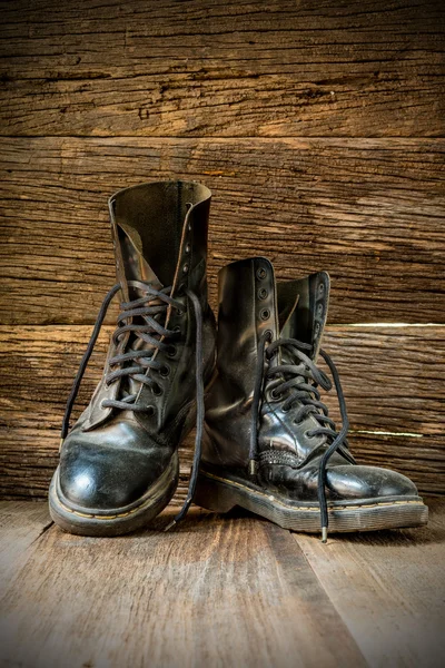 Par de botas viejas sobre tablas de madera — Foto de Stock