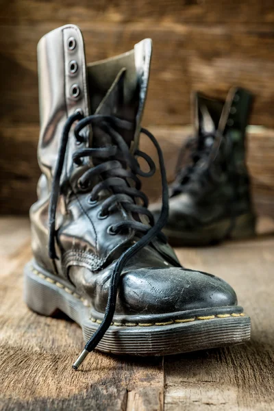 Pair of old boots on wooden floor boards — Stock Photo, Image