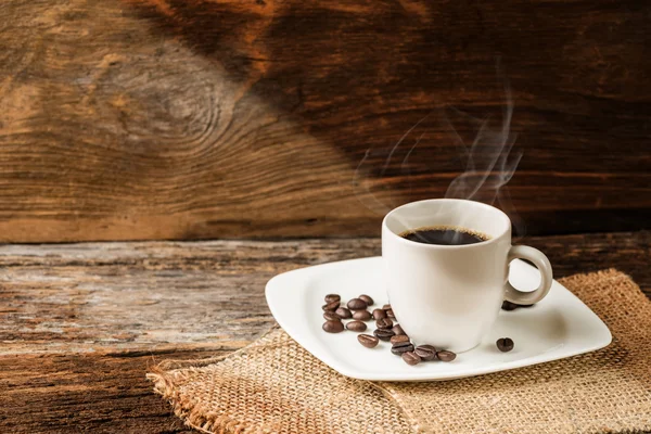 Xícara quente de café no fundo de madeira velha — Fotografia de Stock