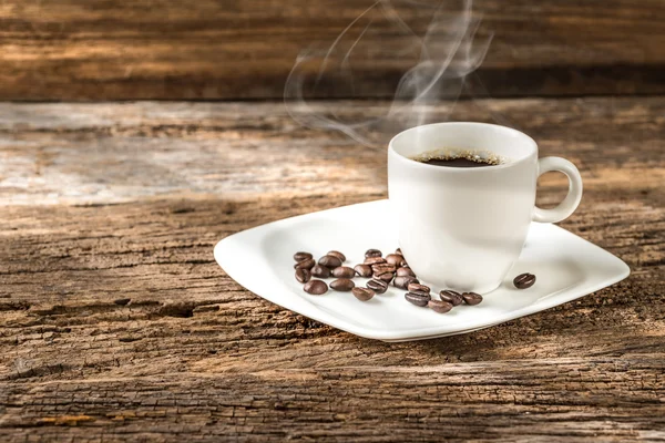 Warm cup of coffee on old wooden background — Stock Photo, Image