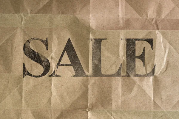 SALE message written on wrinkle brown bag texture — Stock Photo, Image