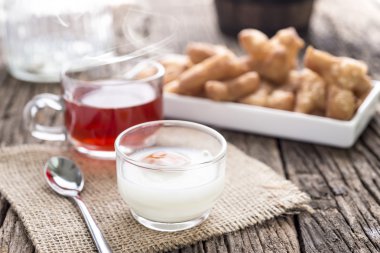 Breakfast with tea , soft boiled egg and  deep-fried dough stick on wooden table,selective focus