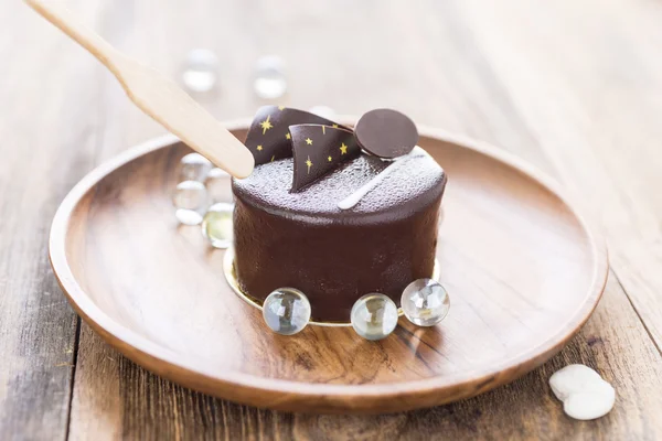 Dark chocolate cake on wooden background — Stock Photo, Image