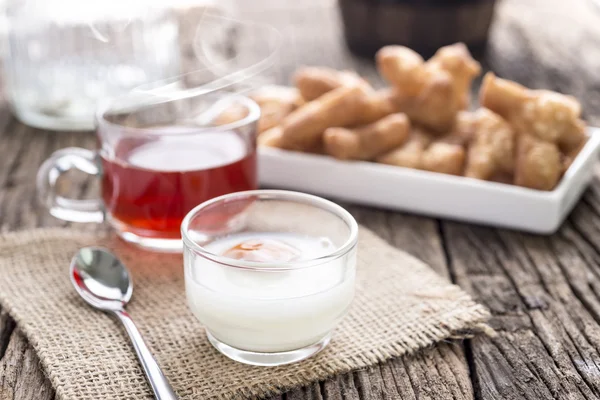 Desayuno con té, huevo blando y masa frita pegada a la mesa de madera, enfoque selectivo —  Fotos de Stock