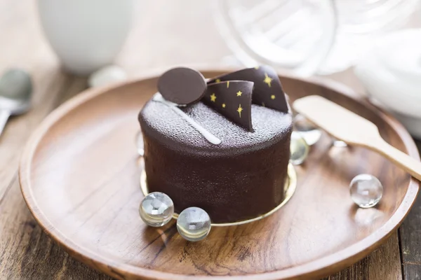 Dark chocolate cake on wooden background — Stock Photo, Image