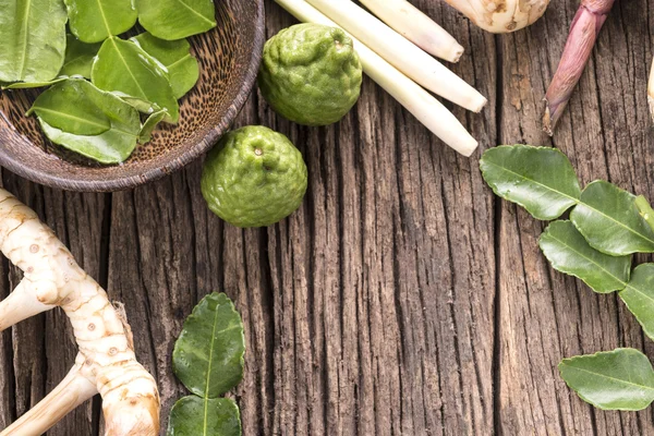 Kräuter und Gewürze vor hölzernem Hintergrund — Stockfoto