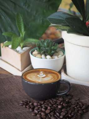 Güzel Latte sanatıyla birlikte bir fincan kahve. Kahve fincanı ve ahşap masa üzerinde kahve sanatı..