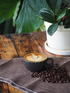 Güzel Latte sanatıyla birlikte bir fincan kahve. Kahve fincanı ve ahşap masa üzerinde kahve sanatı..
