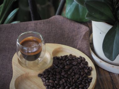 Masada bir fincan espresso. Kokteyl ya da kahve için cam deney şişesi. Bir bardak espresso iç. Beyaz arka planda çift duvarlı sıcak kahve..