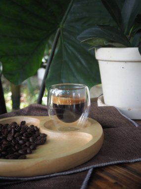 Masada bir fincan espresso. Kokteyl ya da kahve için cam deney şişesi. Bir bardak espresso iç. Beyaz arka planda çift duvarlı sıcak kahve..