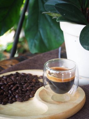 Masada bir fincan espresso. Kokteyl ya da kahve için cam deney şişesi. Bir bardak espresso iç. Beyaz arka planda çift duvarlı sıcak kahve..