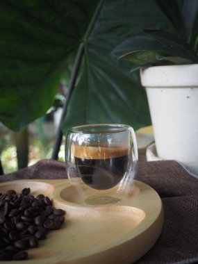 Masada bir fincan espresso. Kokteyl ya da kahve için cam deney şişesi. Bir bardak espresso iç. Beyaz arka planda çift duvarlı sıcak kahve..