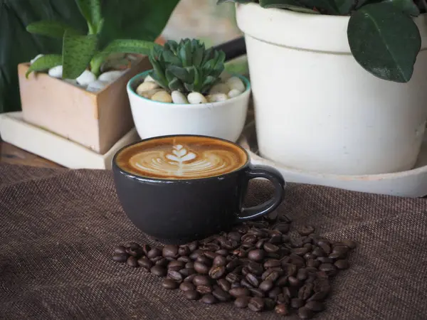 Güzel Latte sanatıyla birlikte bir fincan kahve. Kahve fincanı ve ahşap masa üzerinde kahve sanatı..