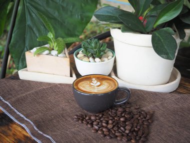 Güzel Latte sanatıyla birlikte bir fincan kahve. Kahve fincanı ve ahşap masa üzerinde kahve sanatı..