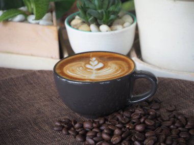 Güzel Latte sanatıyla birlikte bir fincan kahve. Kahve fincanı ve ahşap masa üzerinde kahve sanatı..