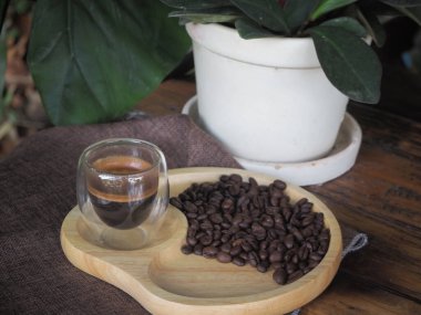 Masada bir fincan espresso. Kokteyl ya da kahve için cam deney şişesi. Bir bardak espresso iç. Beyaz arka planda çift duvarlı sıcak kahve..