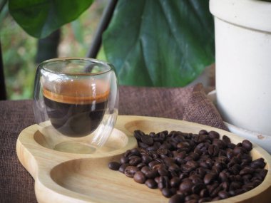 Masada bir fincan espresso. Kokteyl ya da kahve için cam deney şişesi. Bir bardak espresso iç. Beyaz arka planda çift duvarlı sıcak kahve..