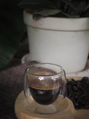 Masada bir fincan espresso. Kokteyl ya da kahve için cam deney şişesi. Bir bardak espresso iç. Beyaz arka planda çift duvarlı sıcak kahve..