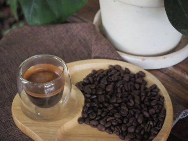 Masada bir fincan espresso. Kokteyl ya da kahve için cam deney şişesi. Bir bardak espresso iç. Beyaz arka planda çift duvarlı sıcak kahve..