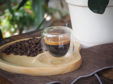 Masada bir fincan espresso. Kokteyl ya da kahve için cam deney şişesi. Bir bardak espresso iç. Beyaz arka planda çift duvarlı sıcak kahve..