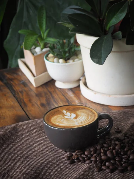 Güzel Latte sanatıyla birlikte bir fincan kahve. Kahve fincanı ve ahşap masa üzerinde kahve sanatı..