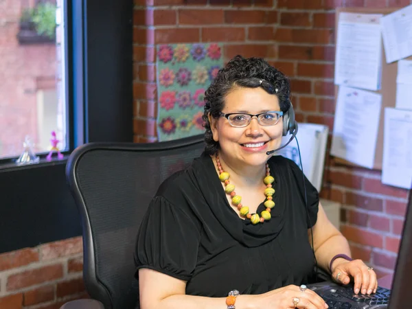 Middle Aged Hispanic Female In Office Environment Wearing Headphones — Stock Photo, Image