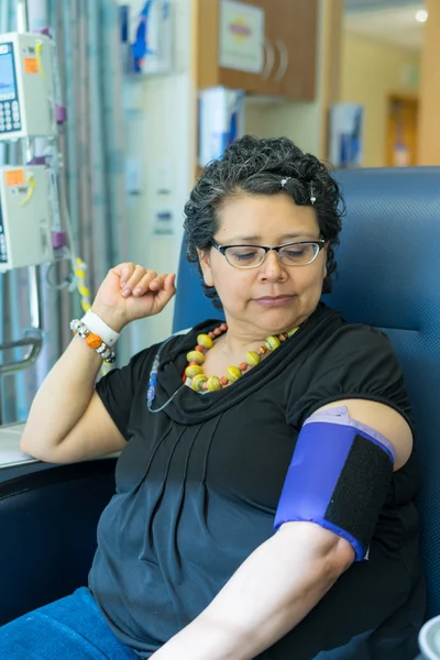 Mujer hispana espera pacientemente durante infusión de tratamiento de quimioterapia —  Fotos de Stock