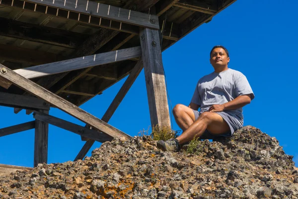 Man Crouched Atop Granite Rocks — Stock Photo, Image