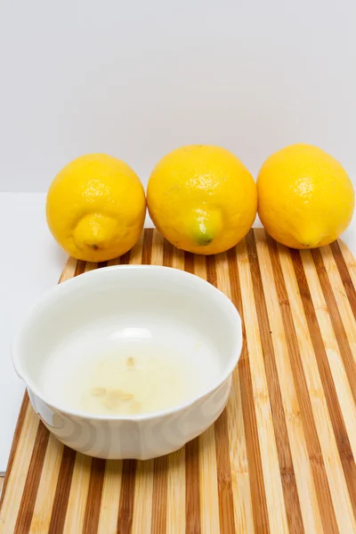 Freshly squeezed lemon juice inside a white bowl — Stock Photo, Image