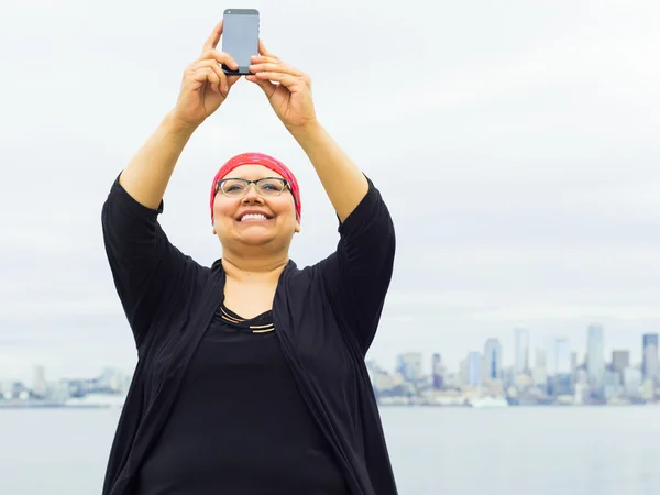 Kadın Selfie şehir manzarası ile arka planda alır.