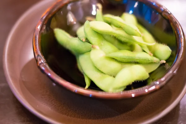 Stängt upp av edamame nibbles, kokta gröna sojabönor, japansk mat — Stockfoto