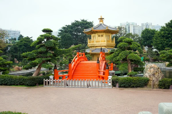 El pabellón de oro y el puente rojo en Nan Lian Garden cerca de Chi Lin Nunnery, famoso monumento en Hong Kong —  Fotos de Stock