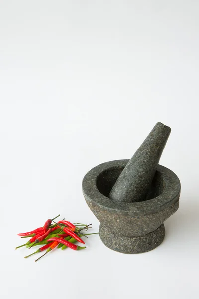 Argamassa, pilão e pimenta vermelha em um fundo branco — Fotografia de Stock