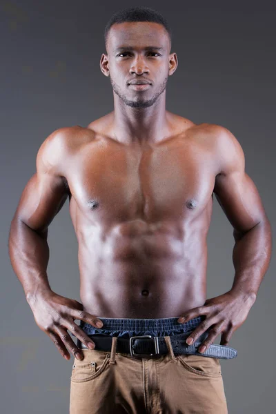 Dark Skinned Male Fitness Model on Grey Background Лицензионные Стоковые Фото