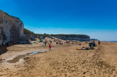 MARGATE, Kent, UK: 21 May 2020: Visitors to Margate's Main Sands beach surrounded by white cliffs during the heatwave in Britain. clipart