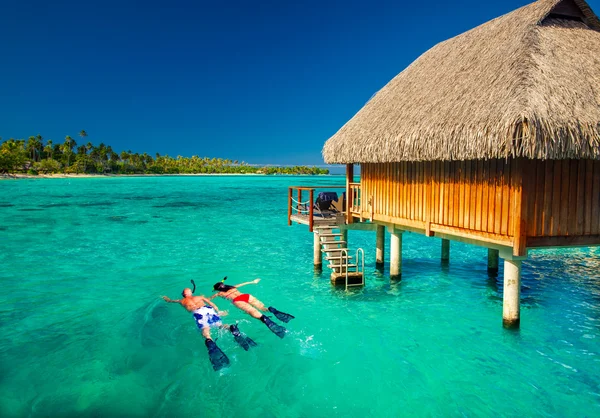 Jovem casal snorkling de cabana sobre lagoa tropical — Fotografia de Stock