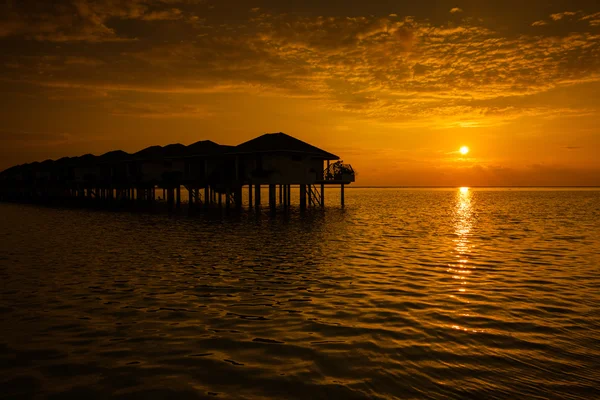 Pôr do sol das Maldivas com silhueta de moradias de água — Fotografia de Stock