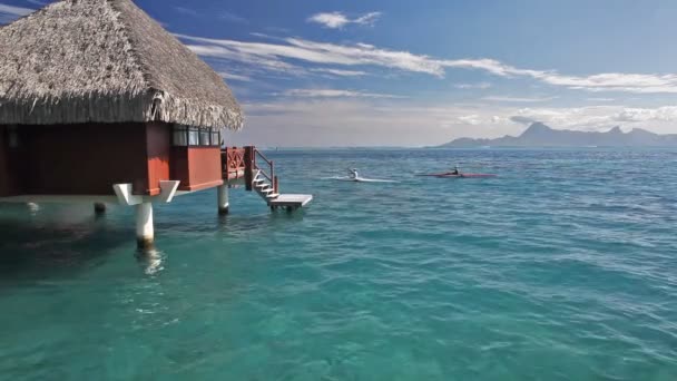 Homme sur des kayaks à côté de bungalow sur l'eau — Video