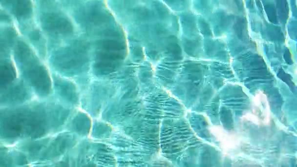 Moving water in swimming pool reflecting sun — Stock Video