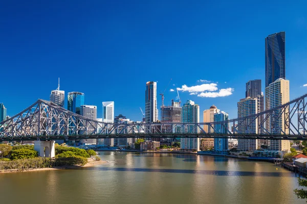 Lodí pod mostem příběh s panorama Brisbane — Stock fotografie