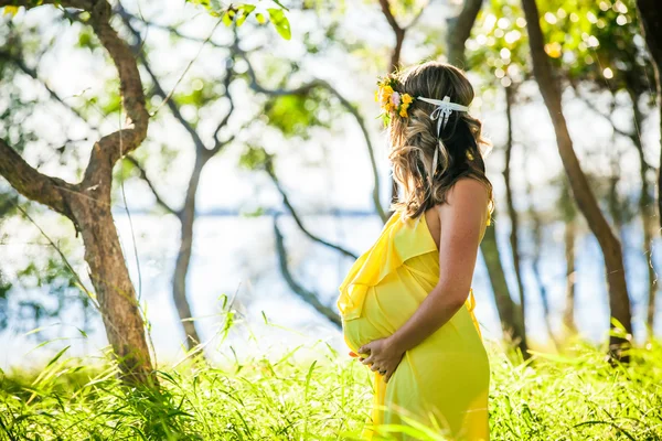 Zwangere vrouw met lang haar op het strand — Stockfoto