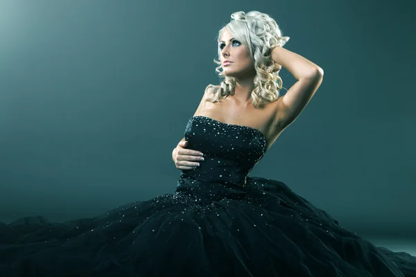 Woman in large formal dress sitting Stock Photo