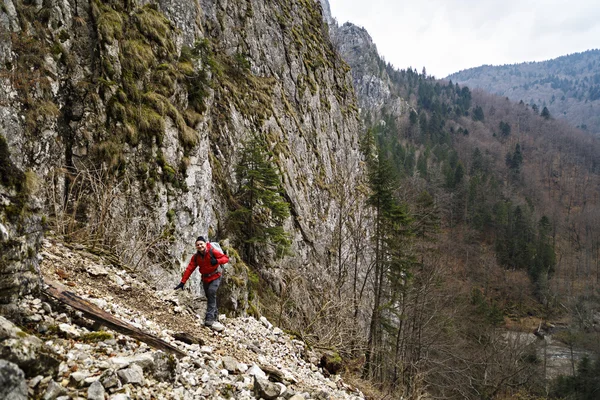 Caucásico hombre con mochila senderismo en las montañas — Foto de Stock