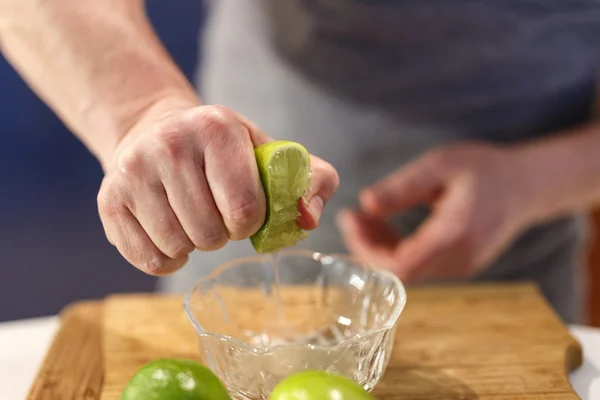 Manos que exprimen una lima — Foto de Stock